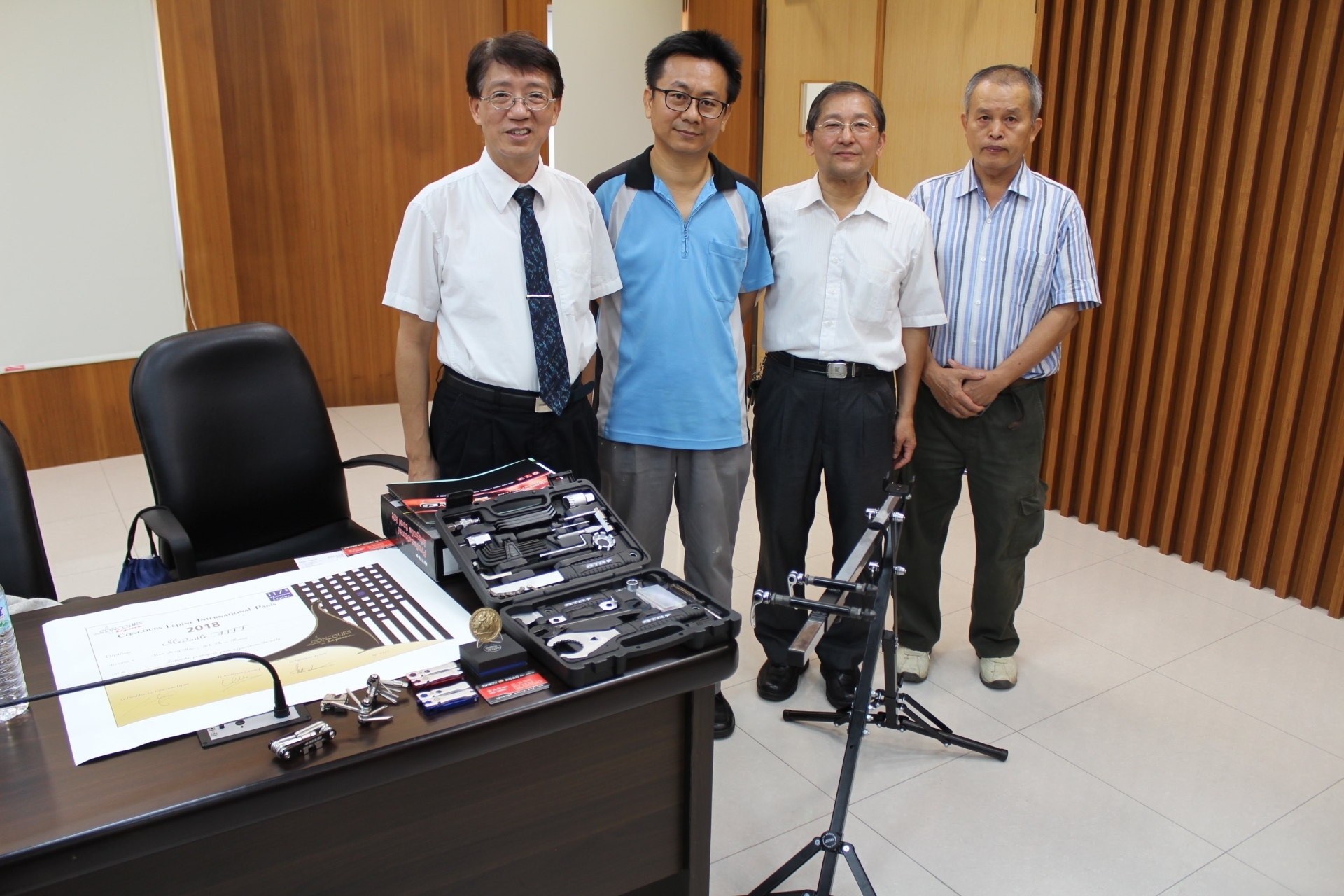 圖五、聯大副校長柳文成(左1)與銅獎愛家企業社自行車工具發明者(左2)合影